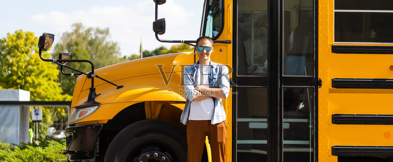 在校车附近微笑的老师的肖像照片摄影图片