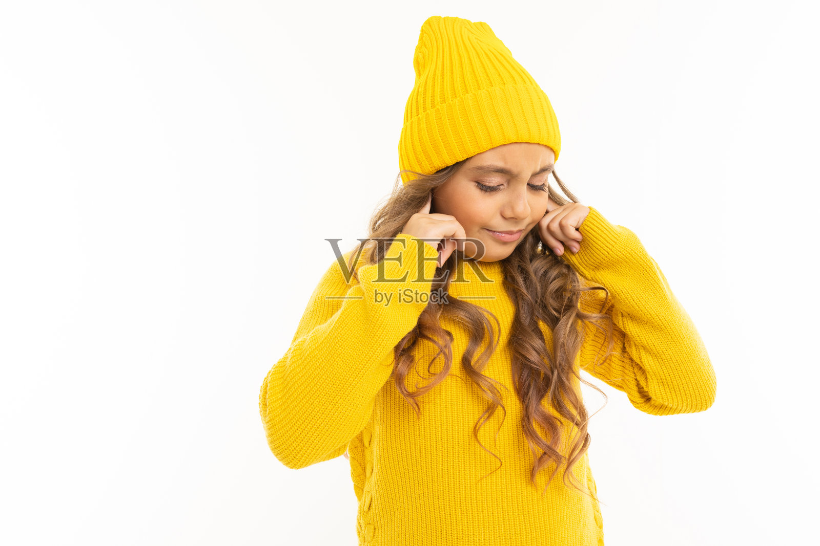 戴着黄色帽子和帽衫的快乐白人女孩不想在白色背景下被孤立照片摄影图片