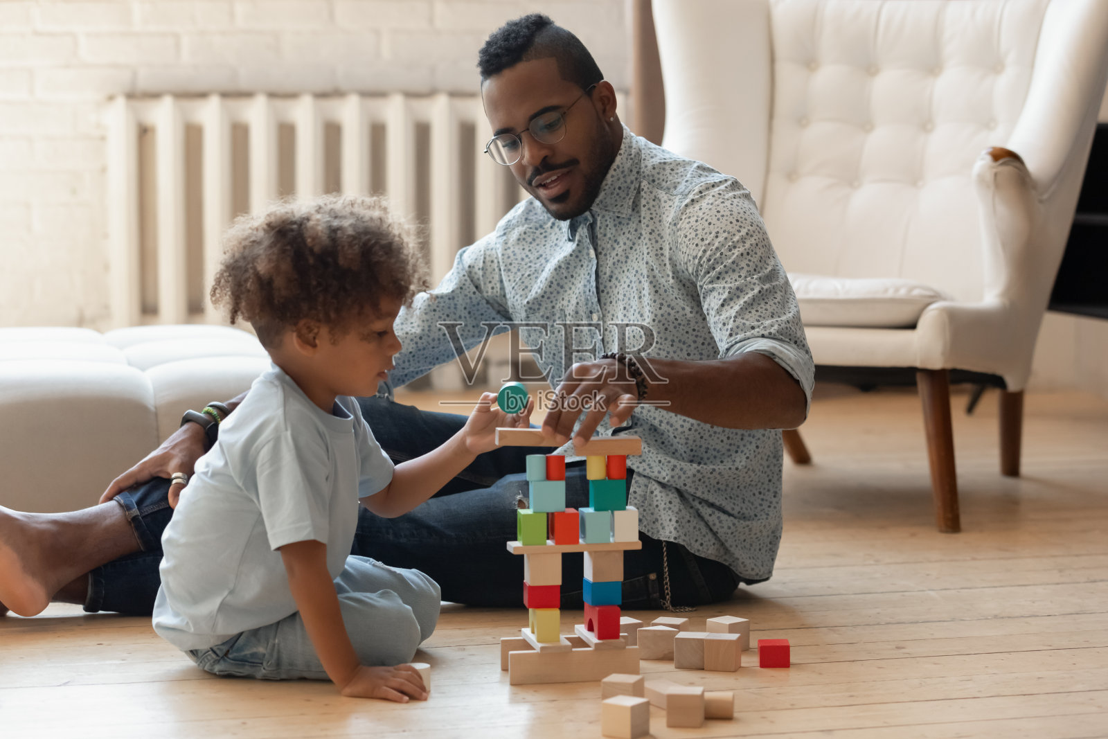慈爱的年轻非洲裔美国人爸爸和儿子玩。照片摄影图片
