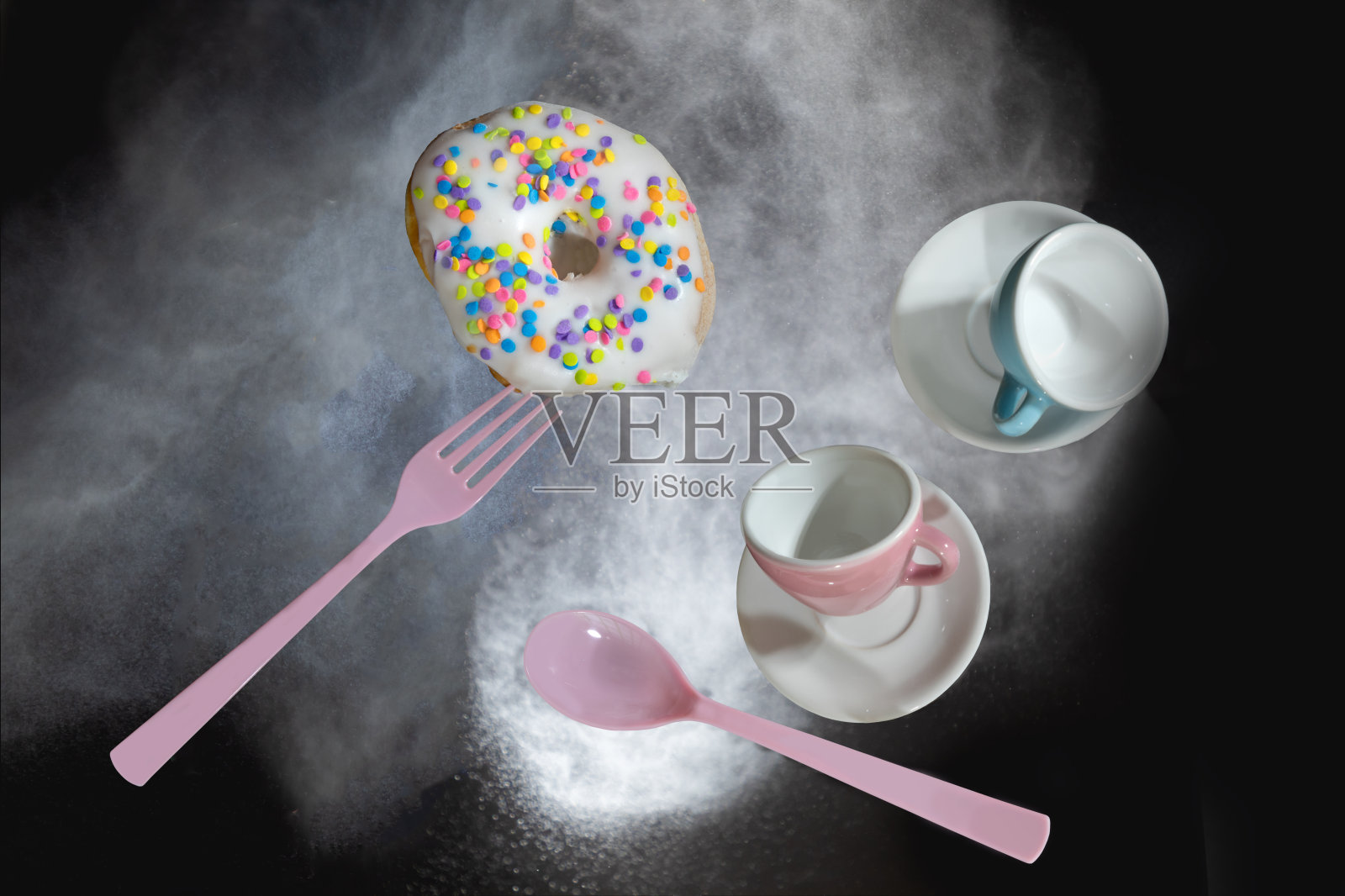 飞飞的甜甜圈，咖啡杯，叉子和勺子在一团面粉中照片摄影图片