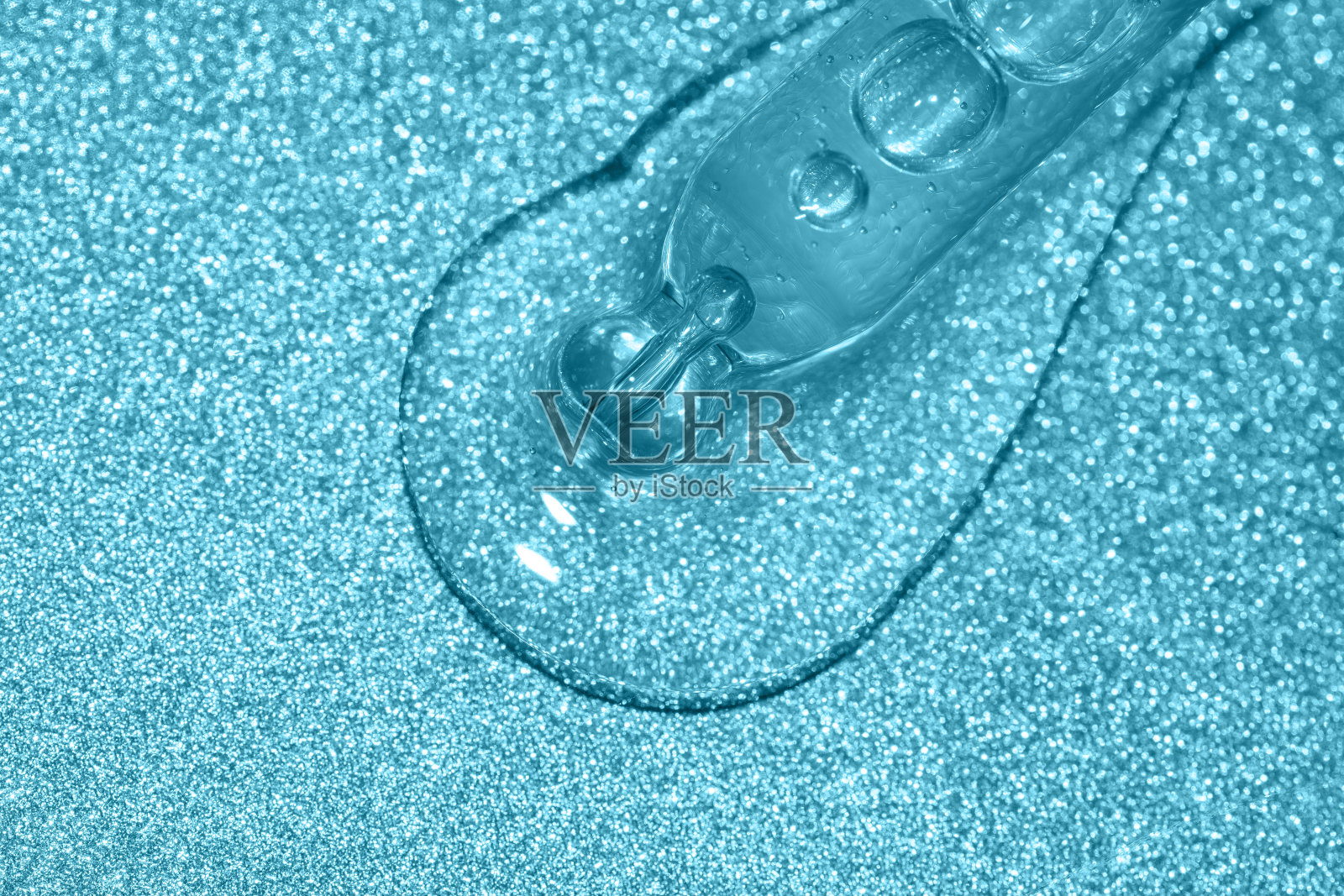 在蓝色闪光的背景下浇注液体的移液管宏照片摄影图片