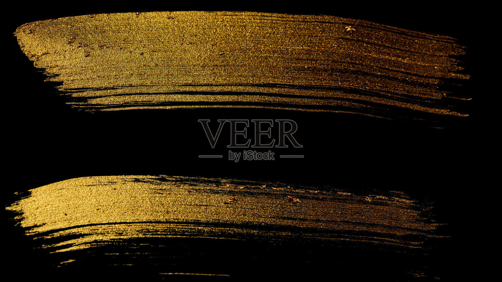 用画笔在黑色的背景上画出金色的痕迹。照片摄影图片