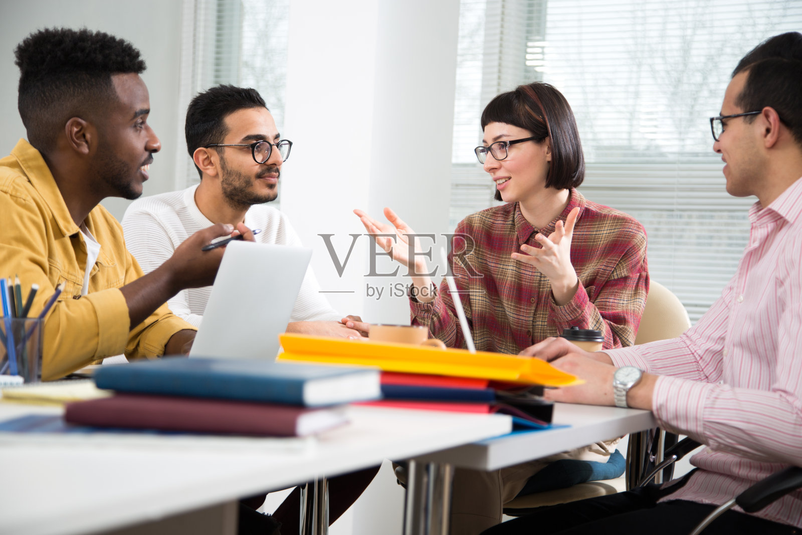 在办公桌旁工作交流的多元种族商务人士照片摄影图片