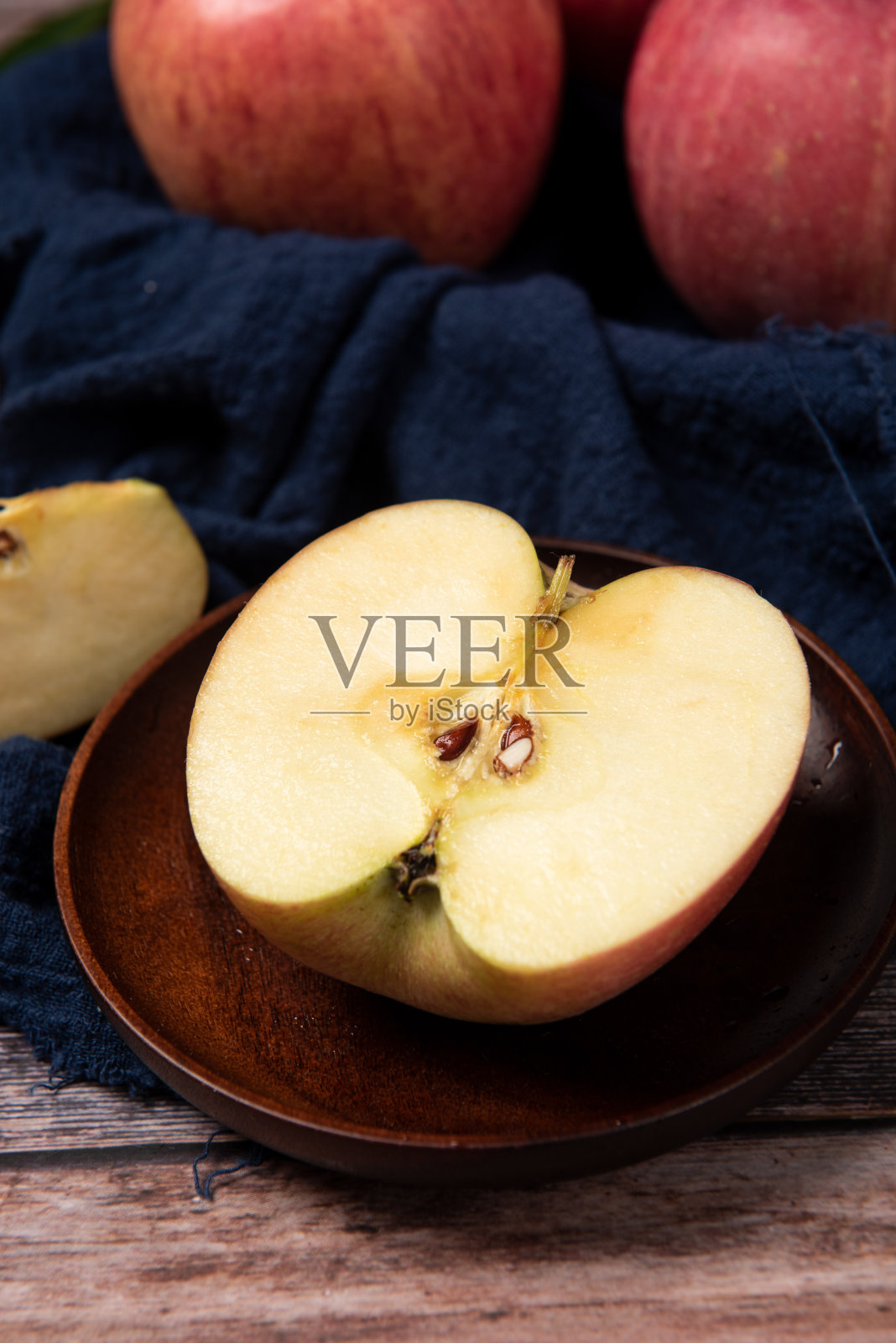 熟透的红苹果在木桌上蜿蜒而过照片摄影图片