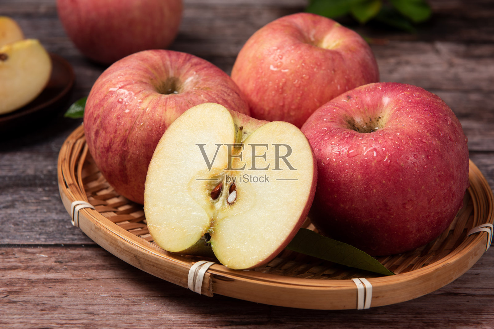 熟透的红苹果在木桌上蜿蜒而过照片摄影图片