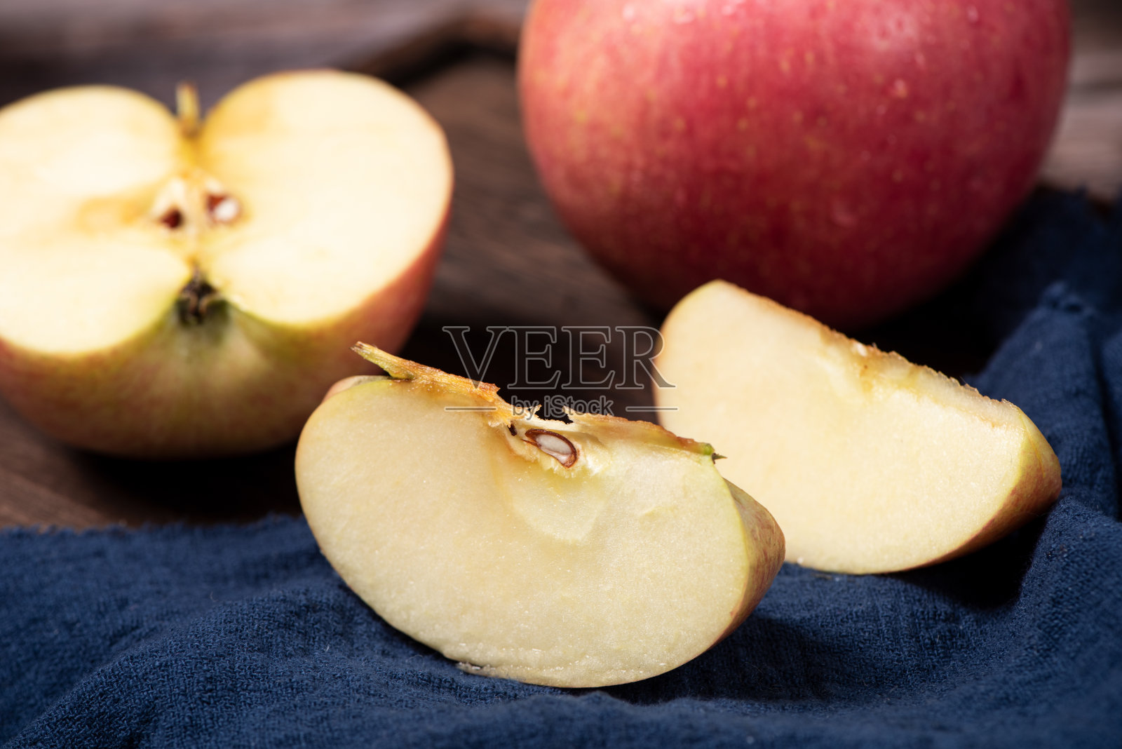 熟透的红苹果在木桌上蜿蜒而过照片摄影图片