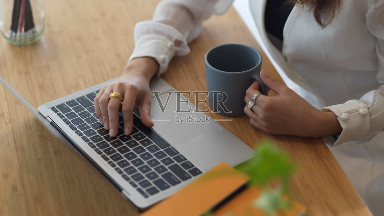 女员工拿着笔记本电脑，拿着咖啡杯放在木桌上照片摄影图片