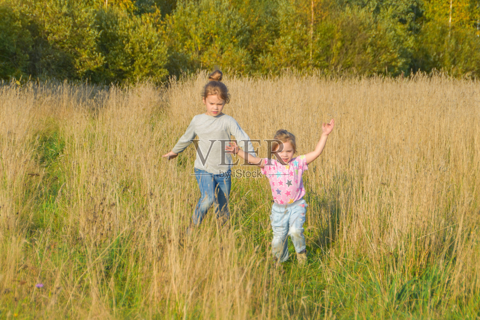 一个阳光明媚的夏日，一个孩子在麦田里跑来跑去照片摄影图片