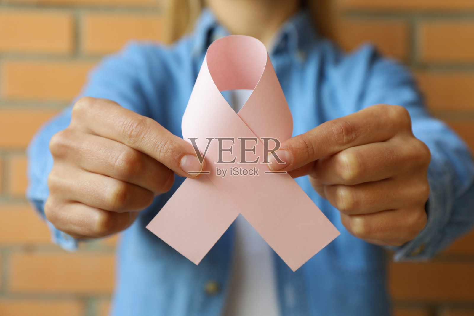 以砖墙为背景的粉红纸彩带女子照片摄影图片