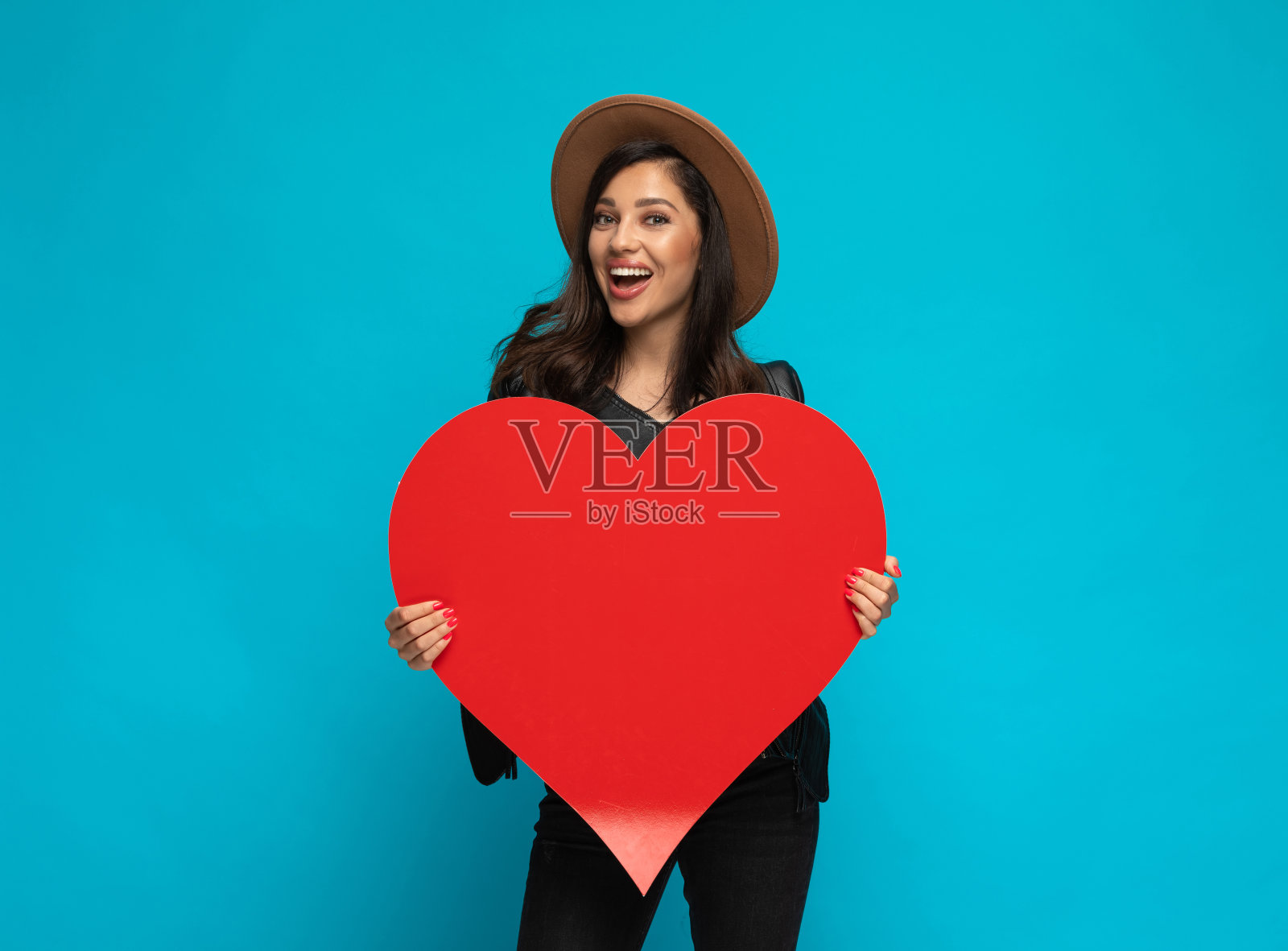 拿着心形并笑着的积极乐观的休闲女人照片摄影图片