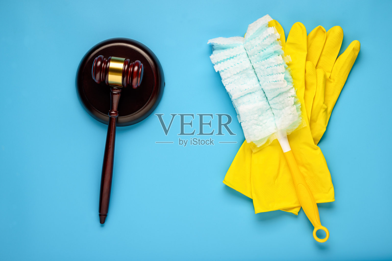 蓝色背景上的橡胶手套和木槌。清洁公司诉讼的概念。照片摄影图片