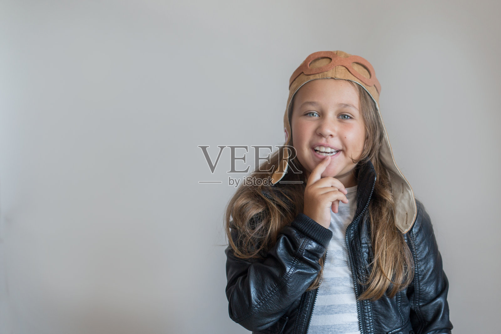 戴着头盔的快乐小女孩，背景是灰色照片摄影图片