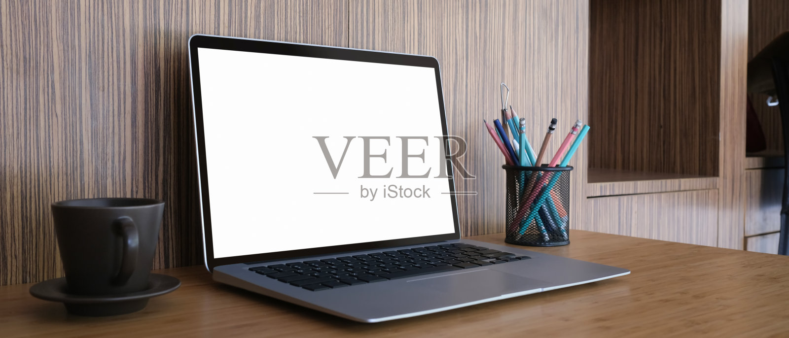 老式的工作空间，笔记本电脑空白屏幕，咖啡杯，文具放在木桌上。照片摄影图片