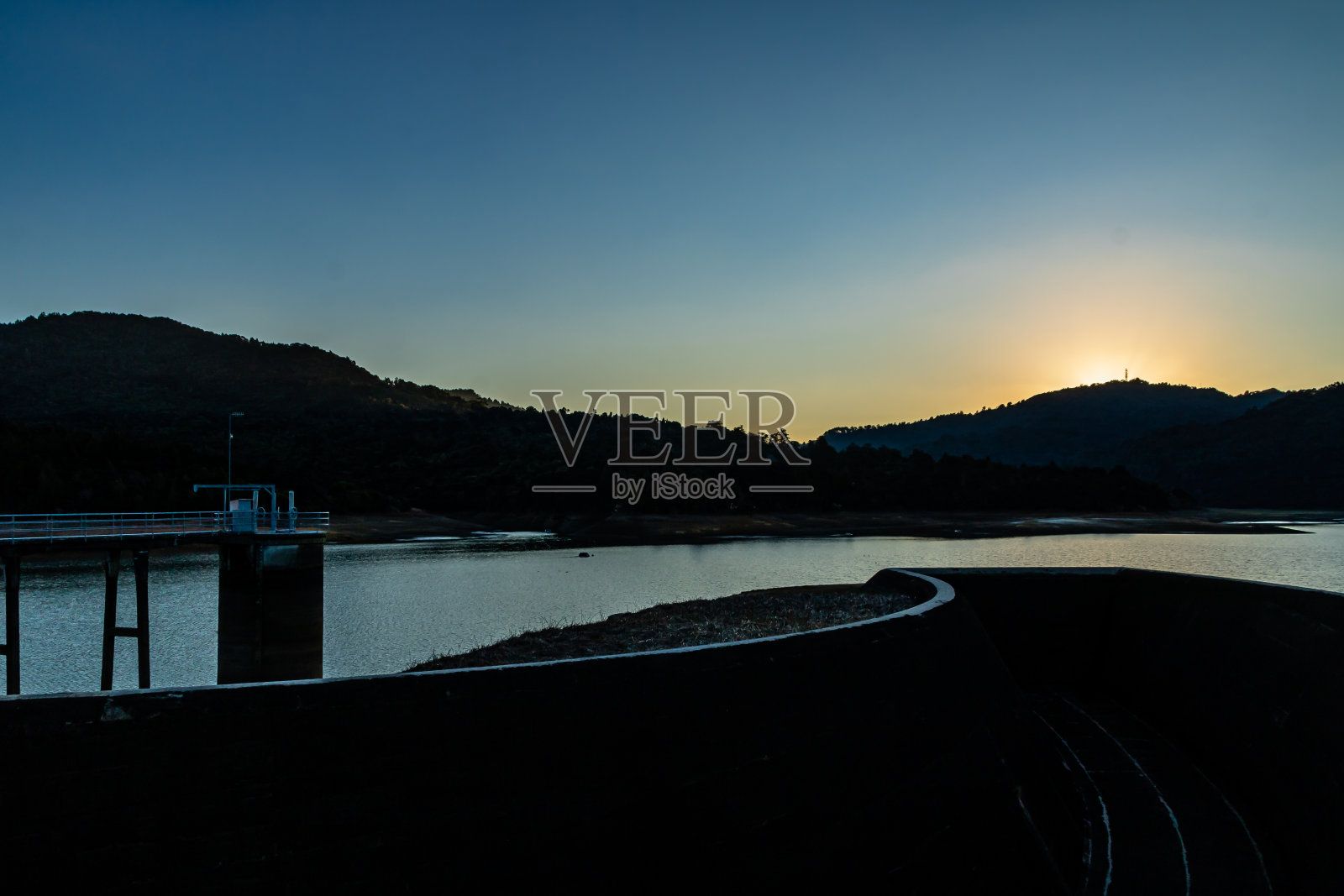 太阳正落在怀塔克里大坝上。奥克兰,新西兰照片摄影图片