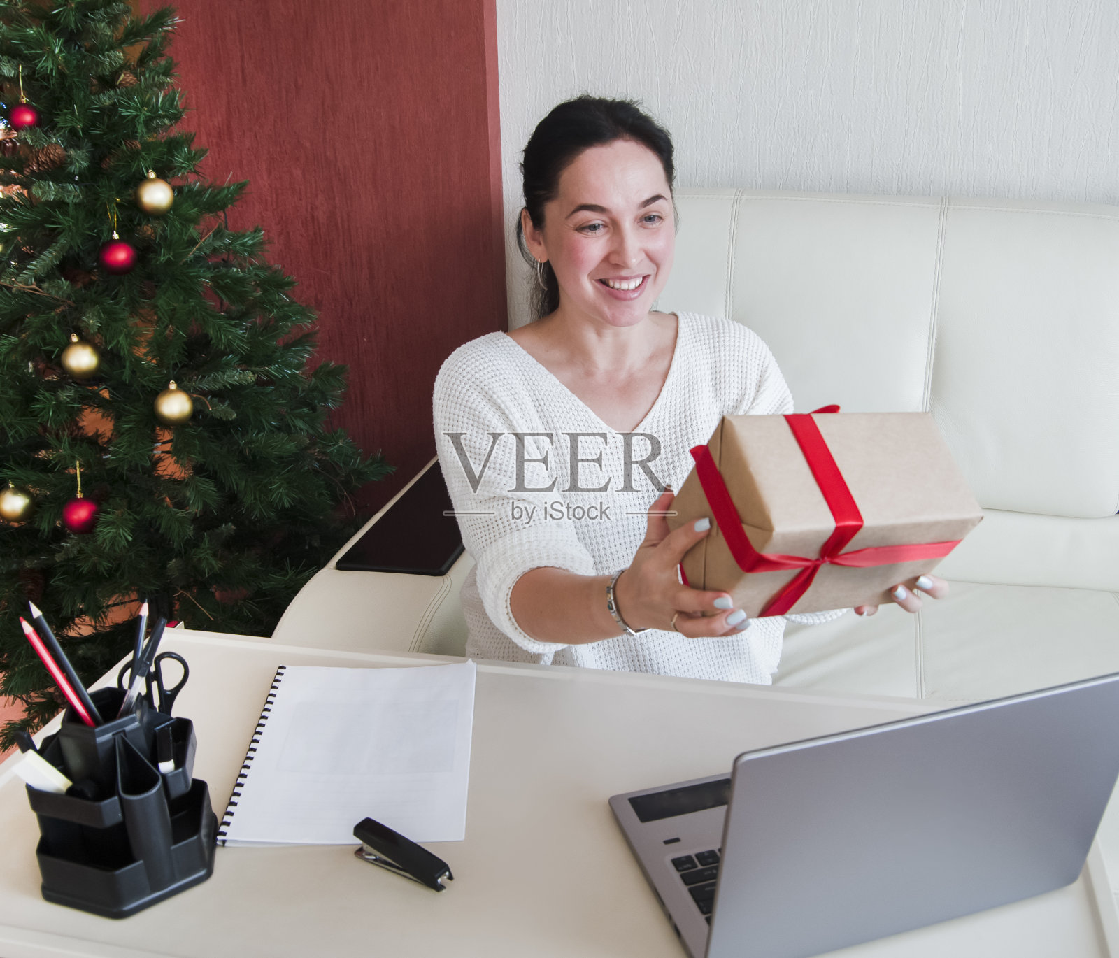 圣诞节网上购物，年轻女子展示收到的订单在一个礼品盒。照片摄影图片