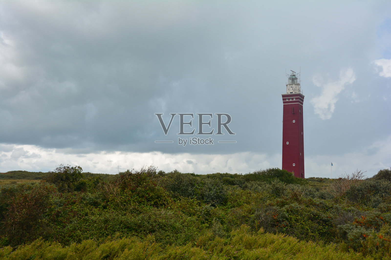 右边是位于荷兰Ouddorp的Westhead灯塔，在一片绿色景观中照片摄影图片