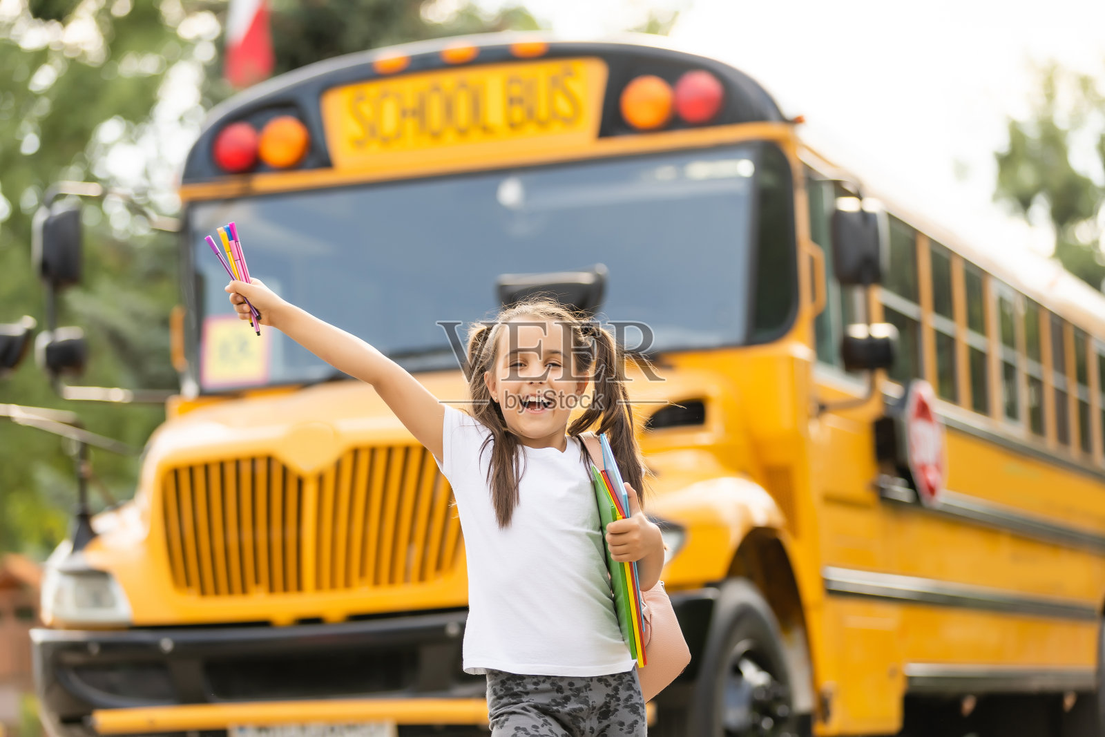 可爱的女孩与一个背包站在公共汽车去学校摆出沉思的特写镜头照片摄影图片