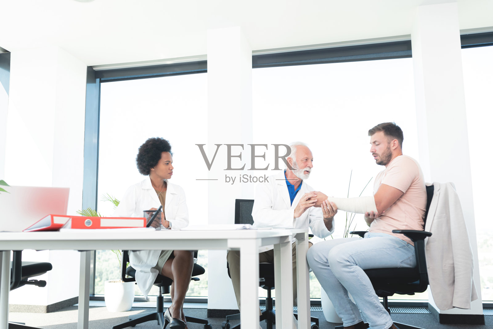 医生检查他手臂受伤的病人照片摄影图片