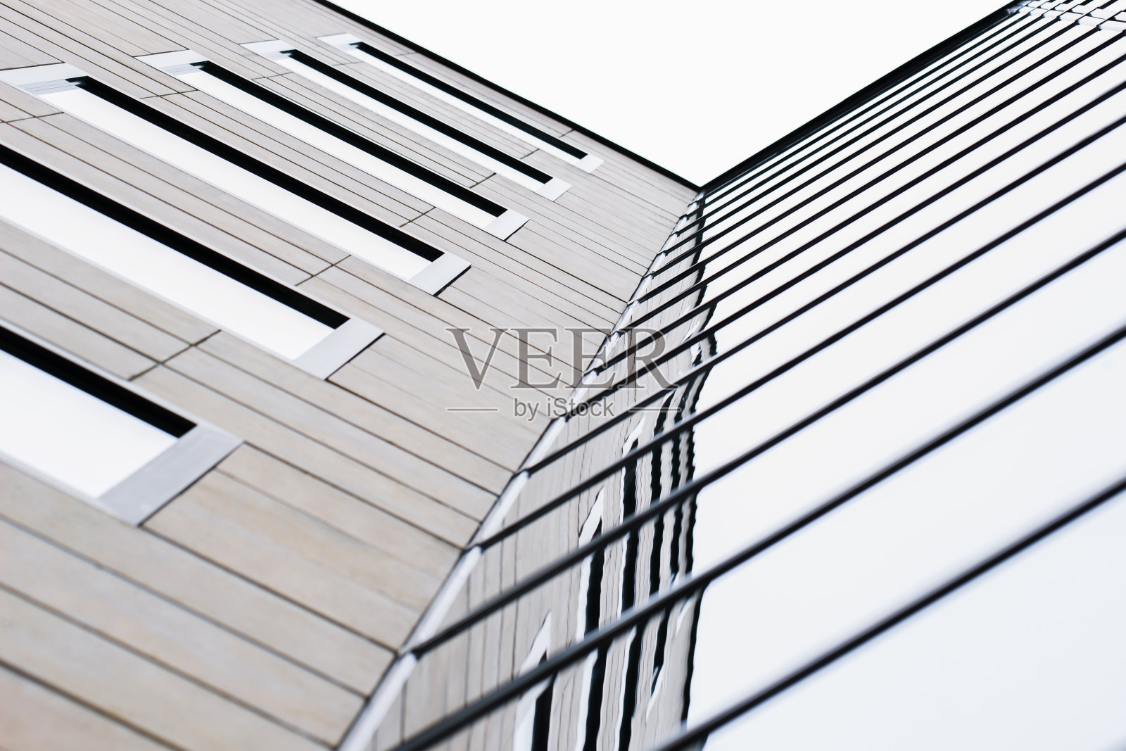 现代多层建筑立面上的木材和玻璃纹理的结合创造了简约、时尚和几何图案。城市抽象的未来主义建筑。照片摄影图片