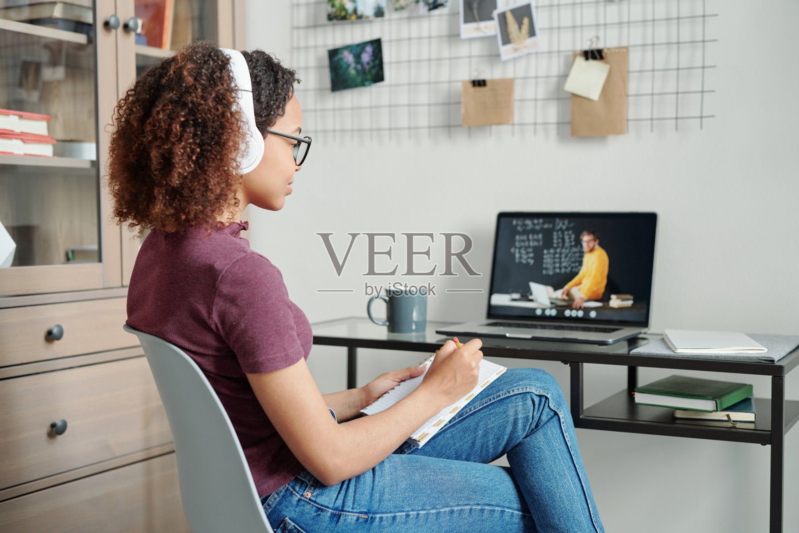 年轻勤奋的女学生穿着休闲装和耳机听老师讲课照片摄影图片