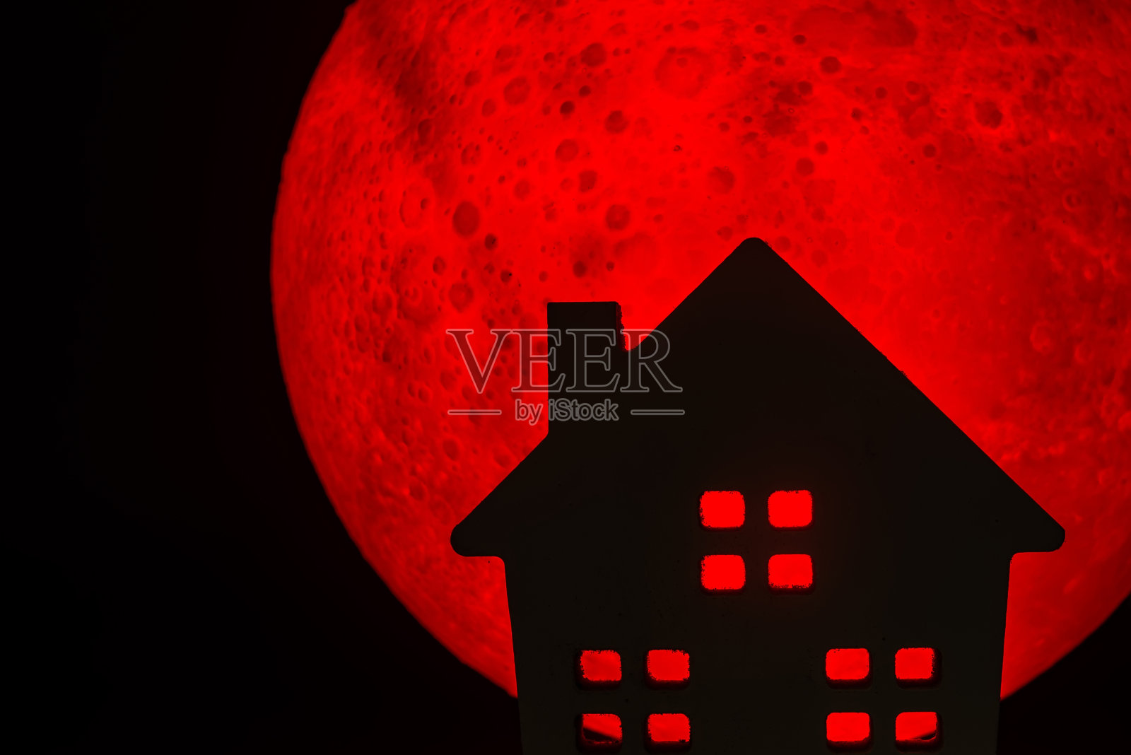 恐怖鬼屋的剪影。背景中有一轮红色的满月。万圣节恐怖的概念。照片摄影图片