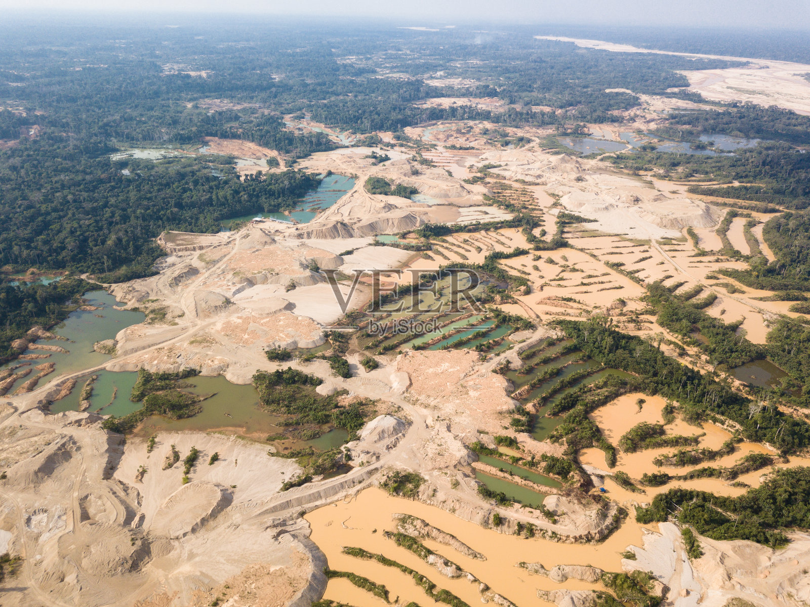 由于非法金矿开采而导致森林砍伐的航拍图像。照片摄影图片