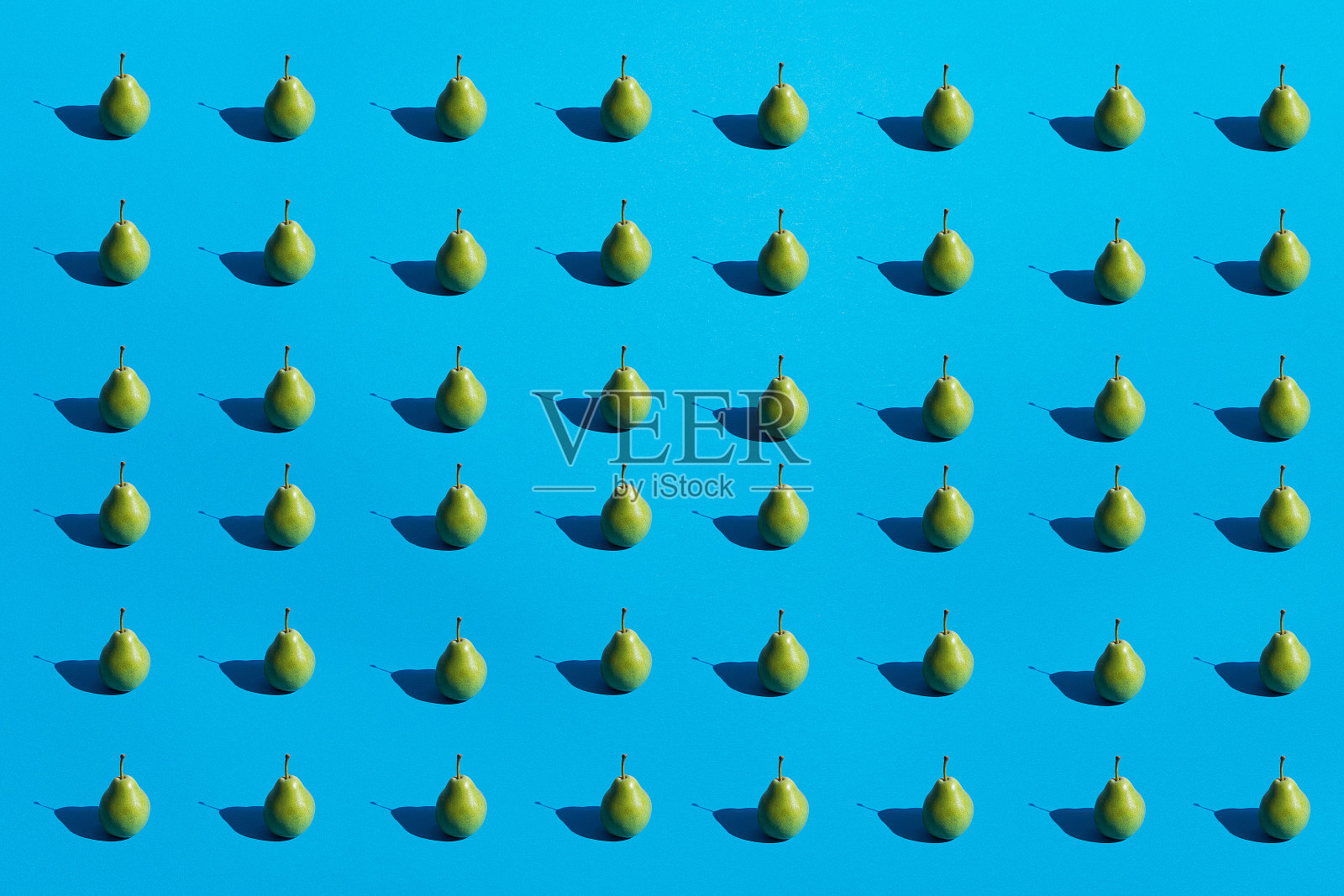 绿鲜梨无缝花纹，黑黑的深阴影在蓝色背景上平铺。简约抽象的形象。健康的有机的概念。俯视图，复制空间。照片摄影图片