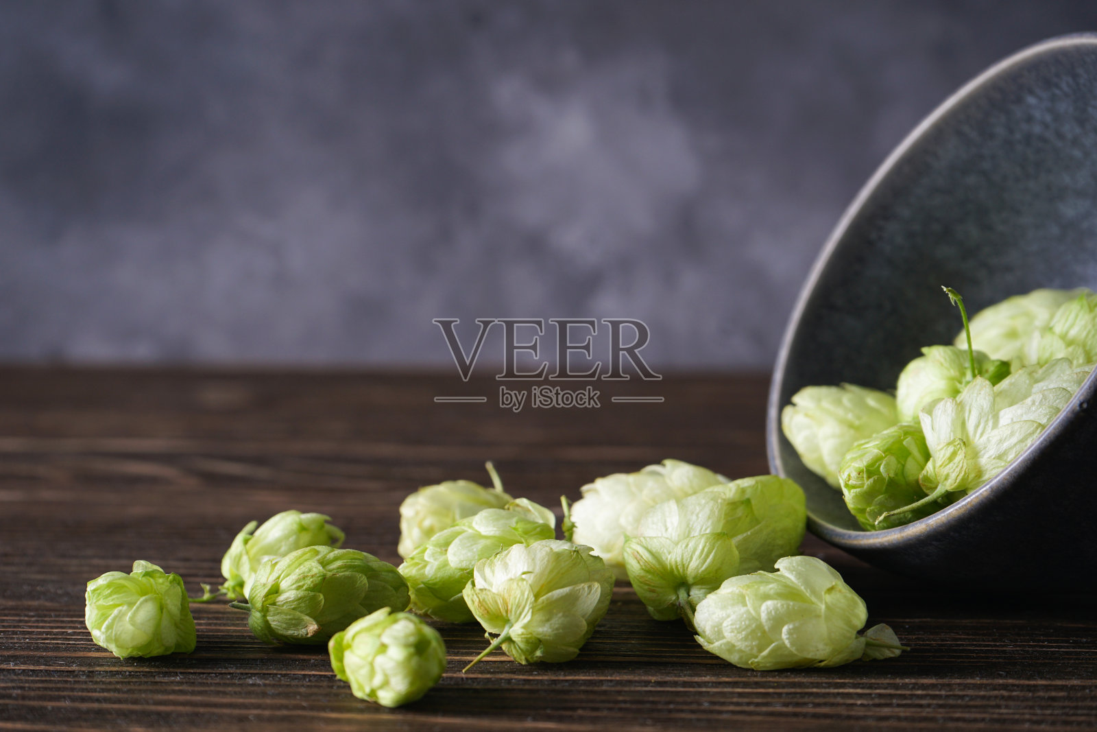 啤酒花在一个碗上的木制背景，文字空间。特写镜头。照片摄影图片