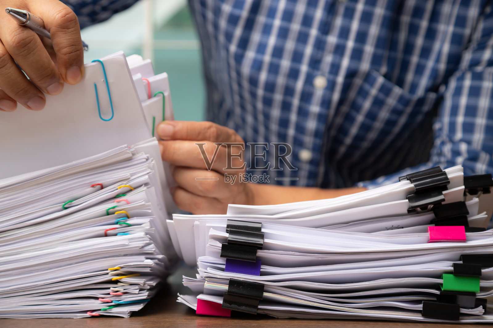 商务人士拾起堆积如山的公文报告纸，经营理念照片摄影图片