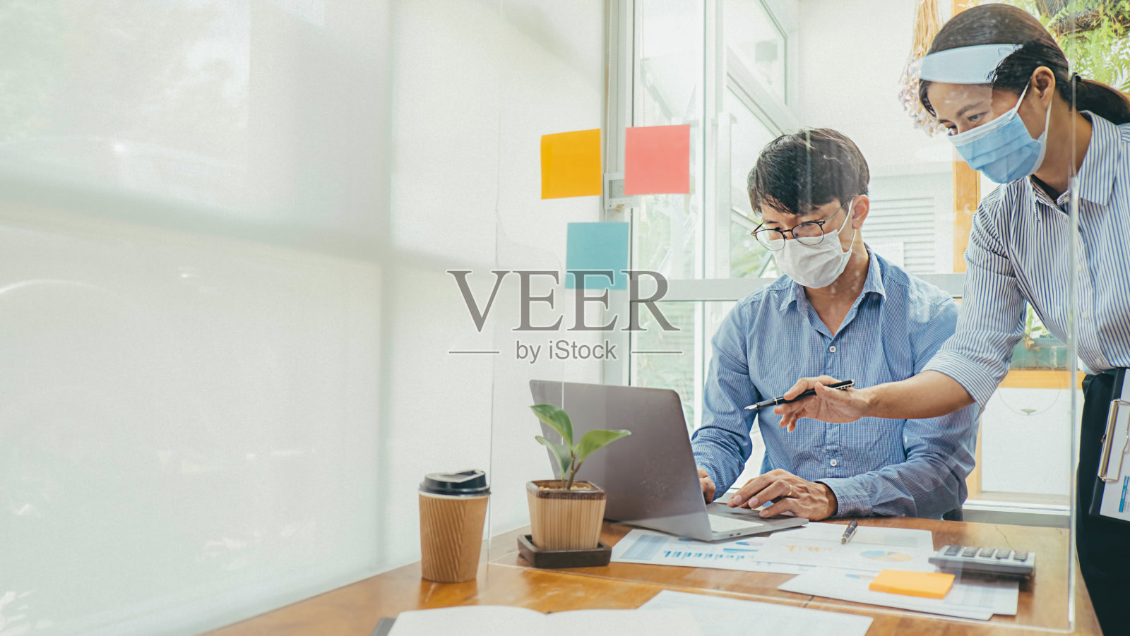 亚洲人成功的团队合作，戴着医用口罩工作。新冠肺炎疫情中私人办公室社交距离的工作照片摄影图片