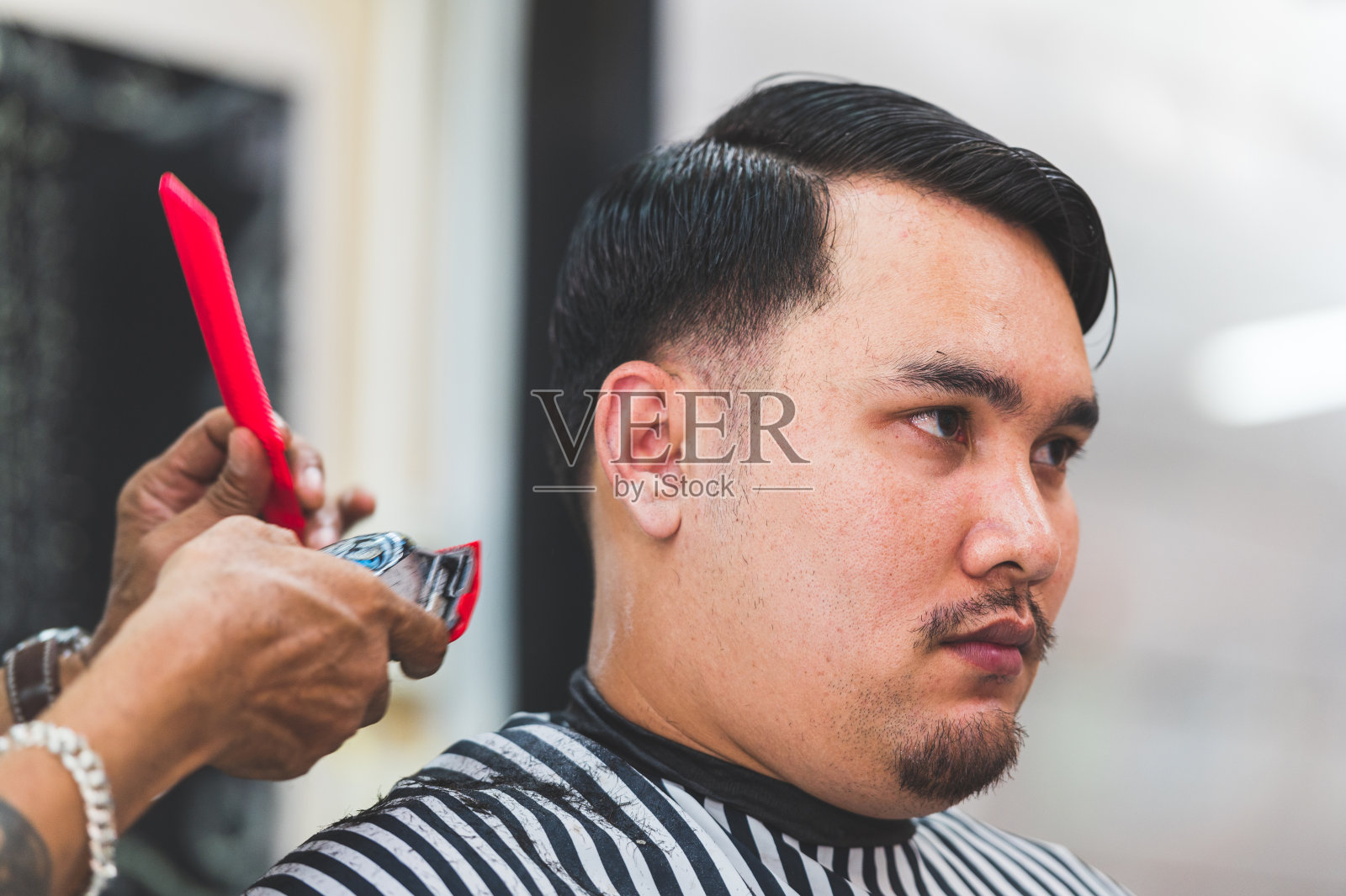 成年男子时尚发型师在理发店为顾客理发照片摄影图片