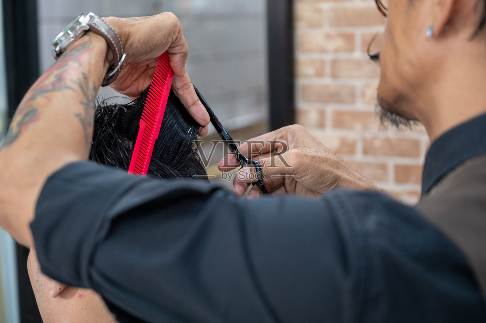 成年男子时尚发型师在理发店为顾客理发照片摄影图片