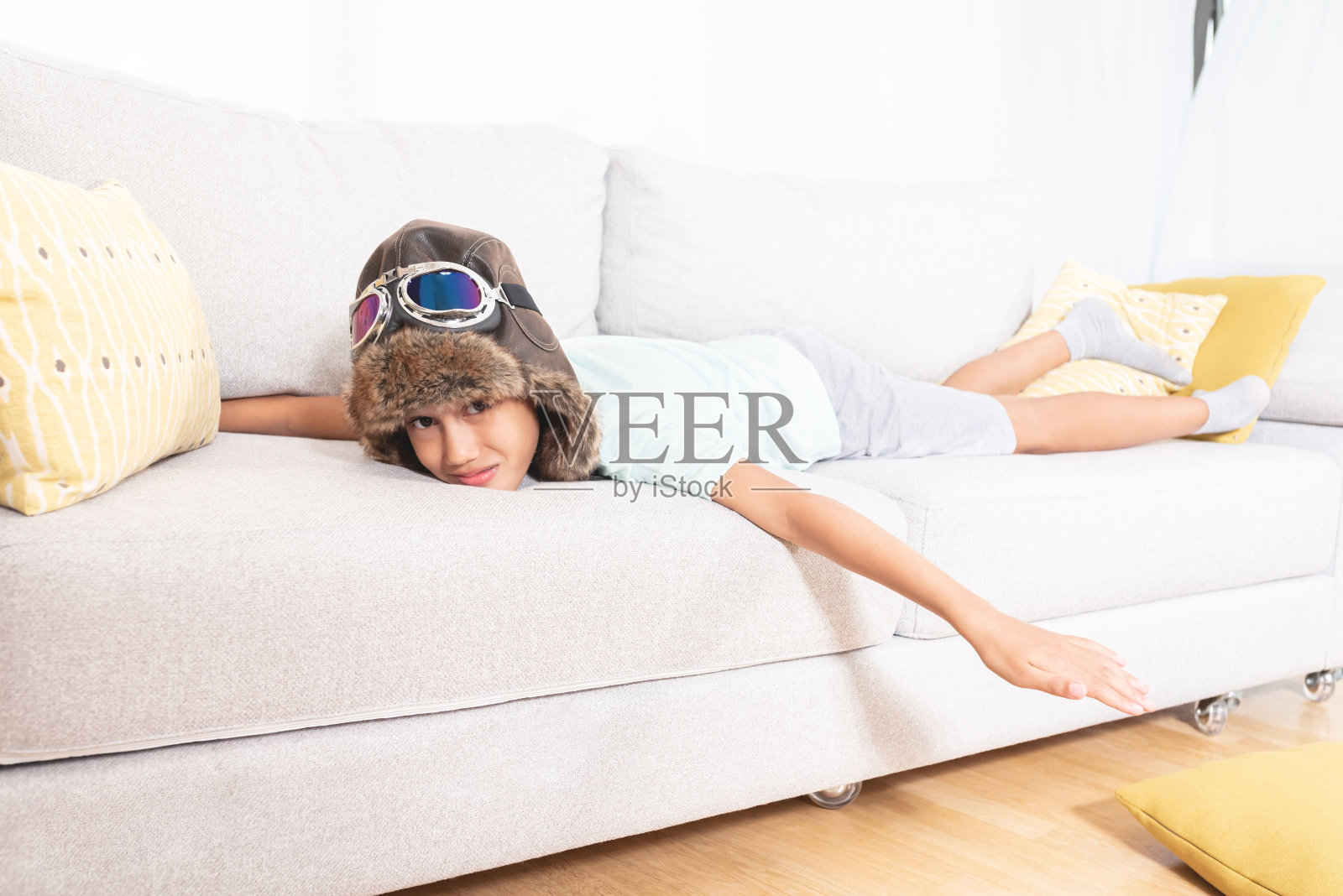 男孩假装在家里的沙发上飞照片摄影图片