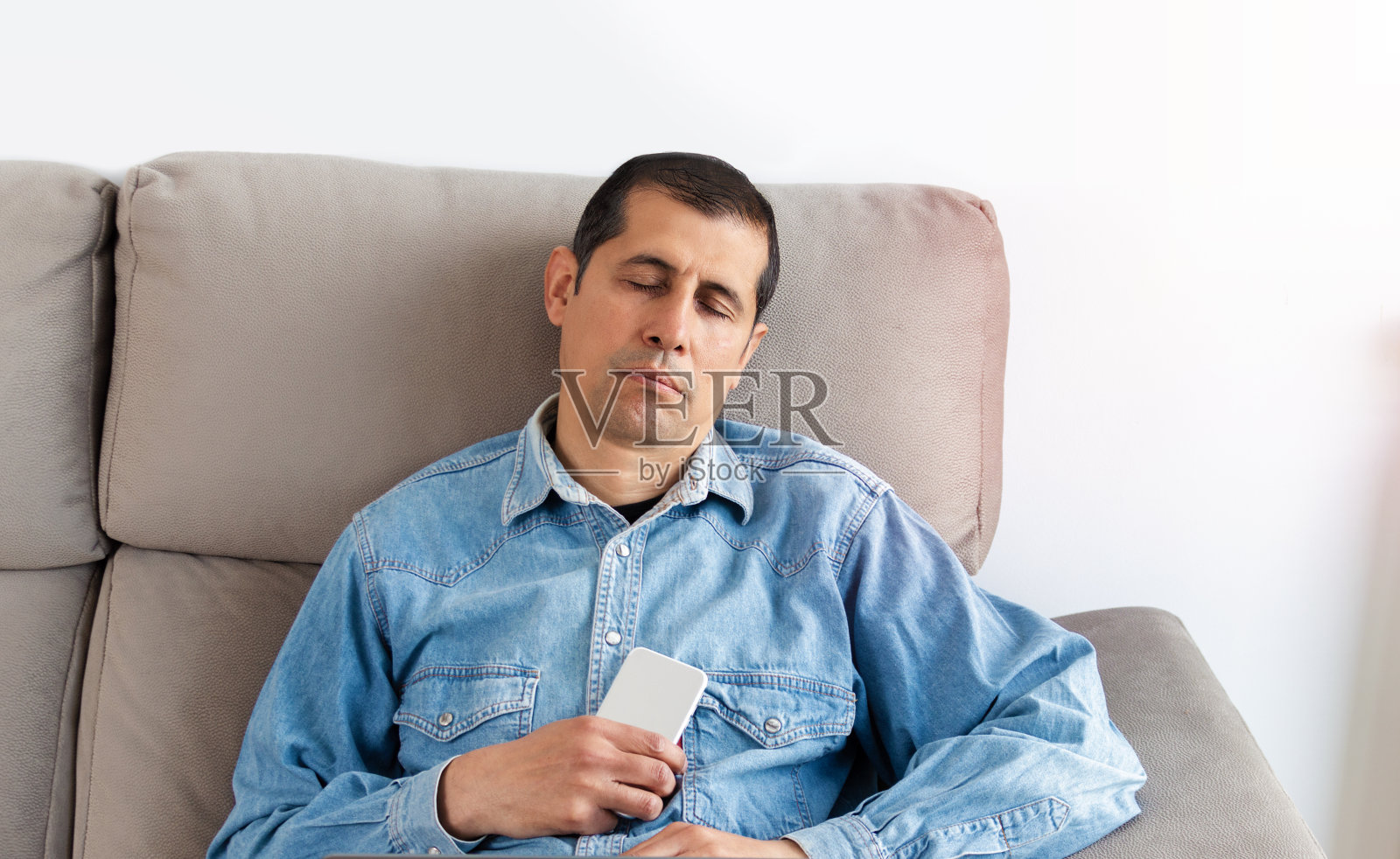 年轻的商人睡在沙发上照片摄影图片