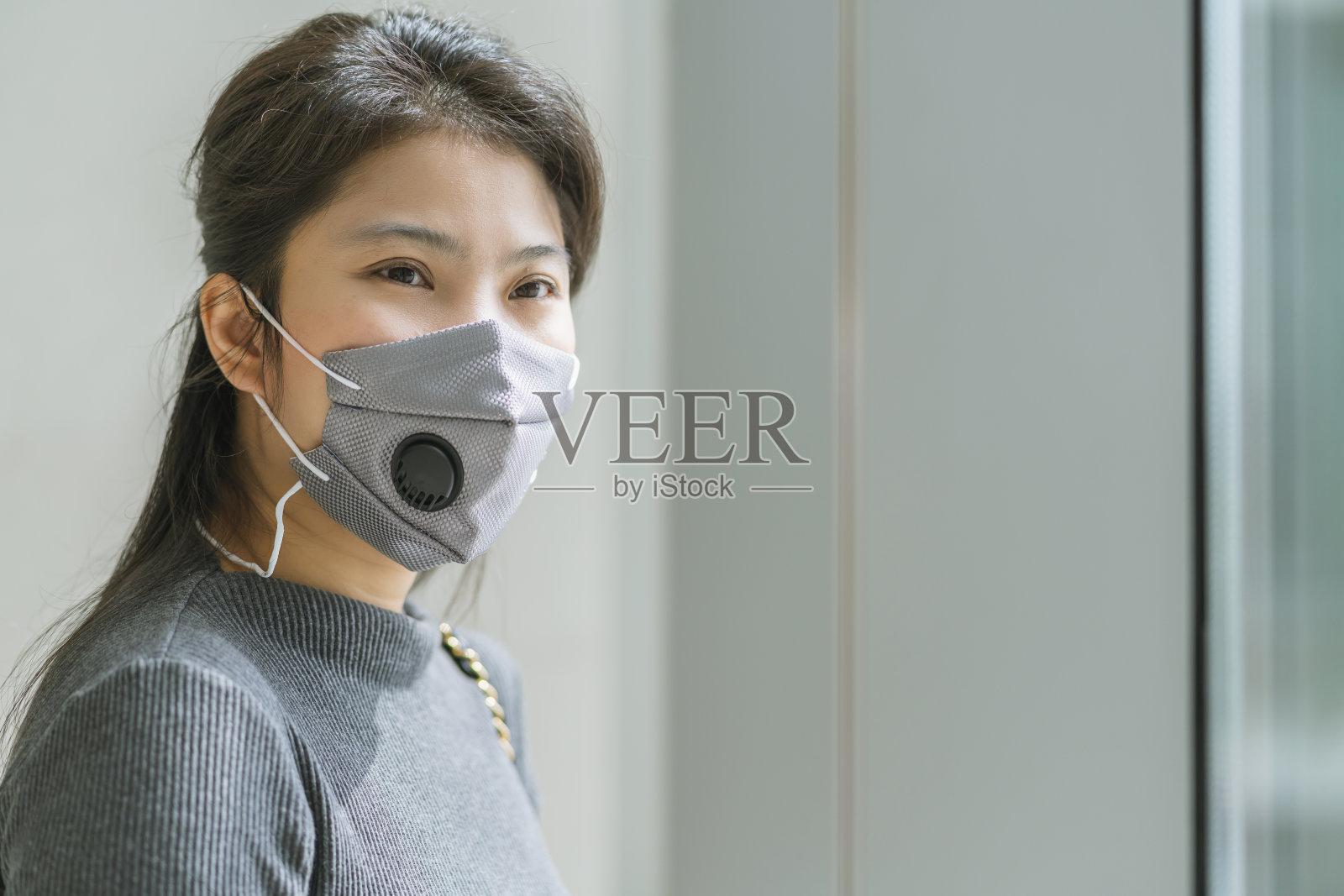 年轻的亚洲女性佩戴防护口罩，以防止病毒传播新的正常生活观念的肖像照片摄影图片