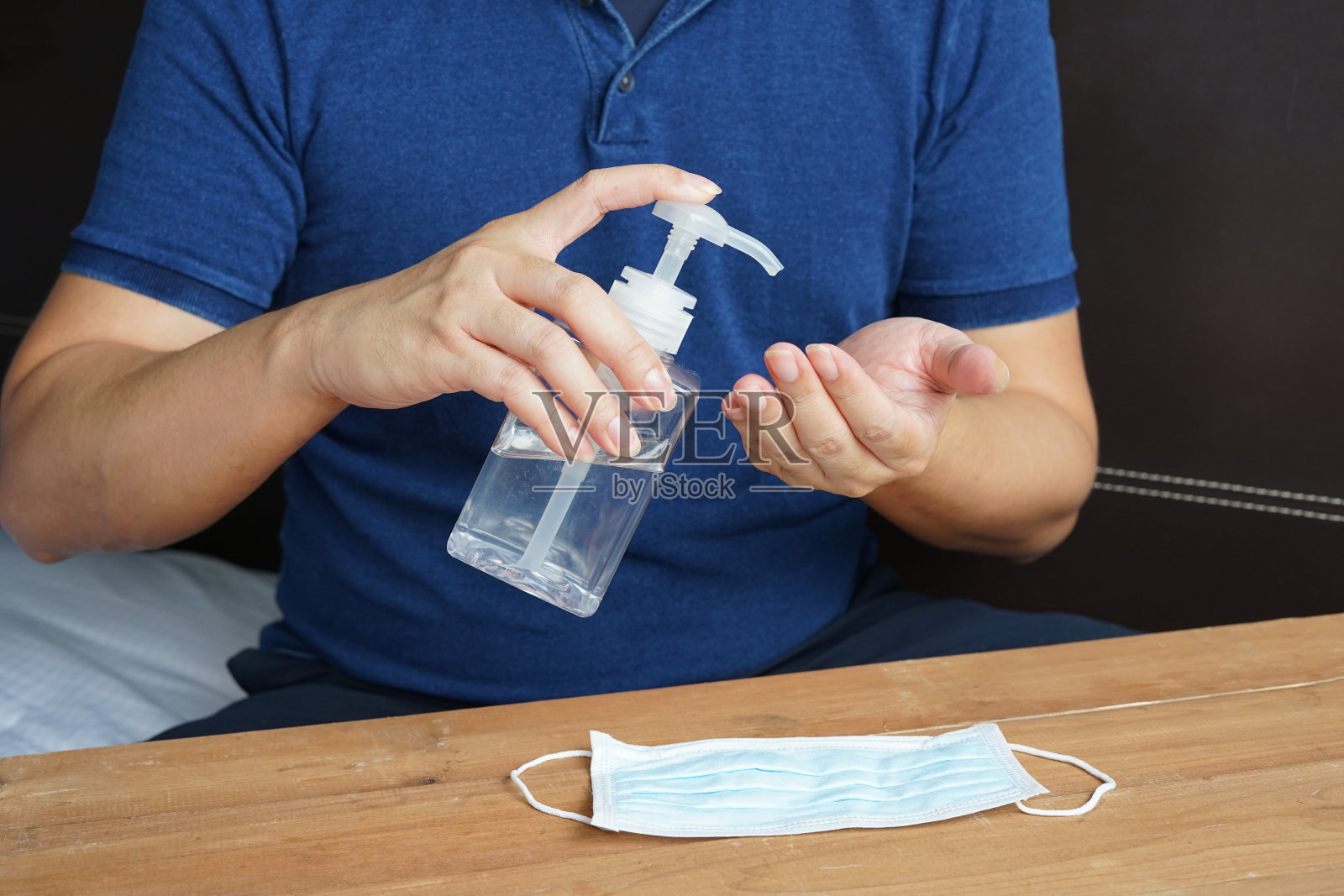 男子使用手卫生凝胶预防冠状病毒肺炎大流行。照片摄影图片