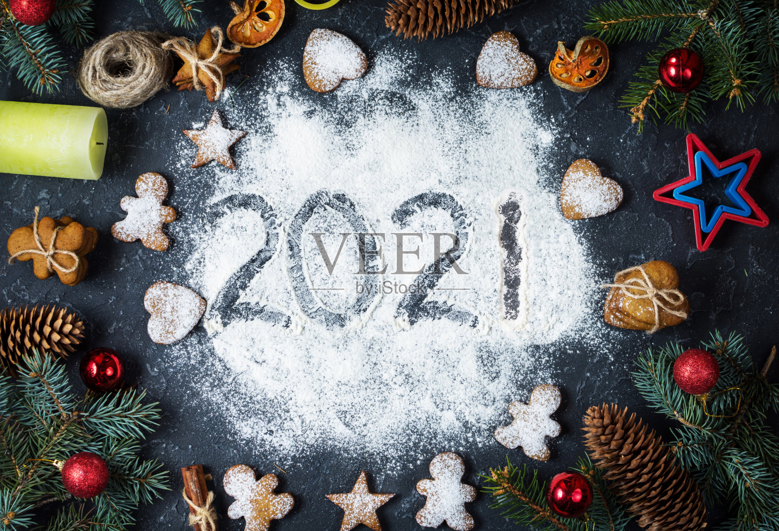 面粉和圣诞装饰品姜饼上写着“2021年新年快乐”。新年贺卡。照片摄影图片