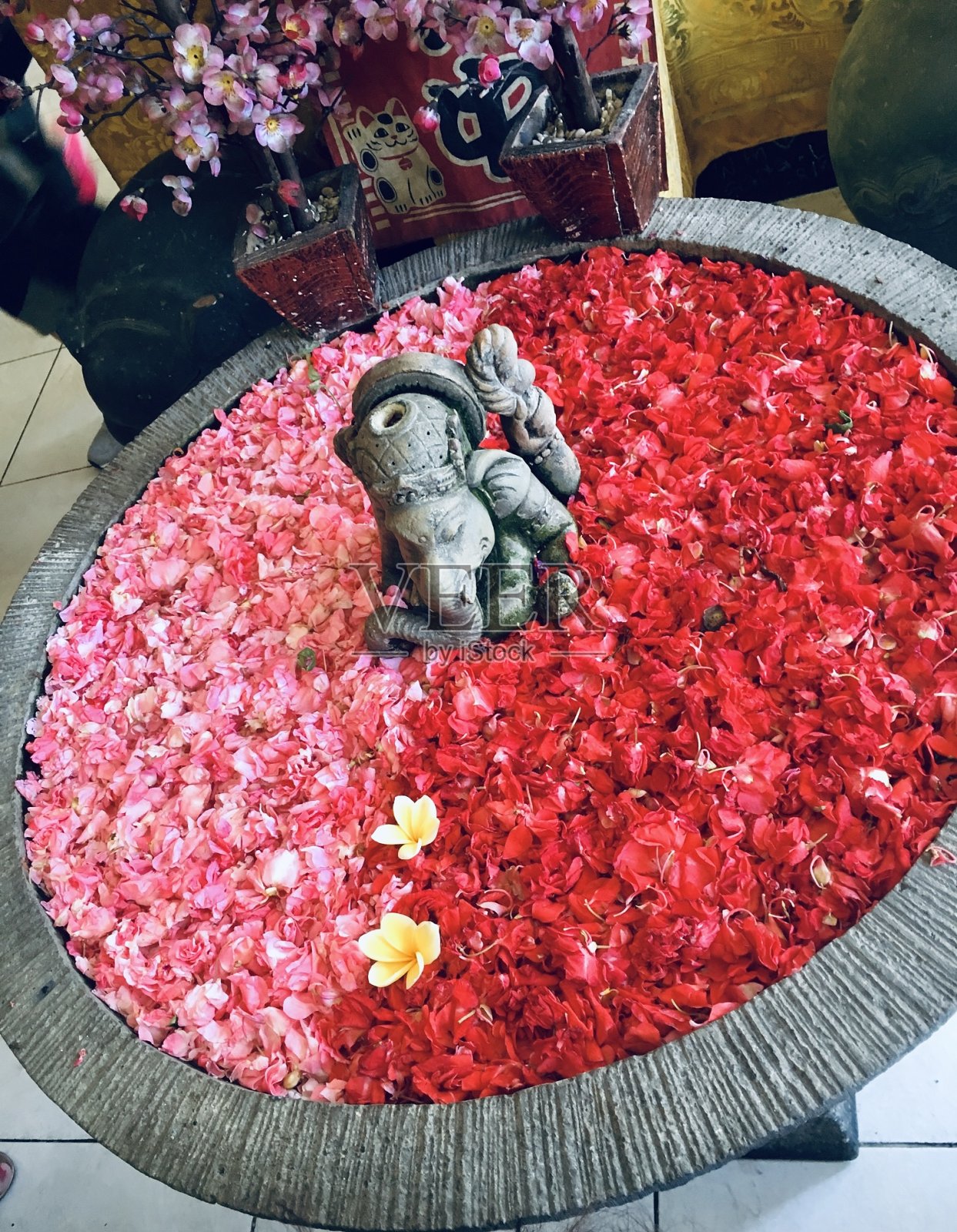 在巴厘岛的一家餐馆里，象头神的神像被鲜花包围着照片摄影图片