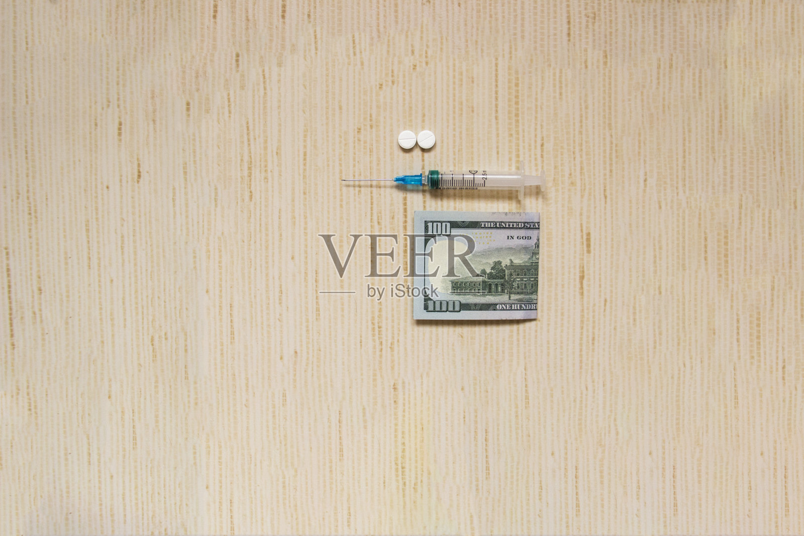 桌上放着一个装着药片的注射器。照片摄影图片