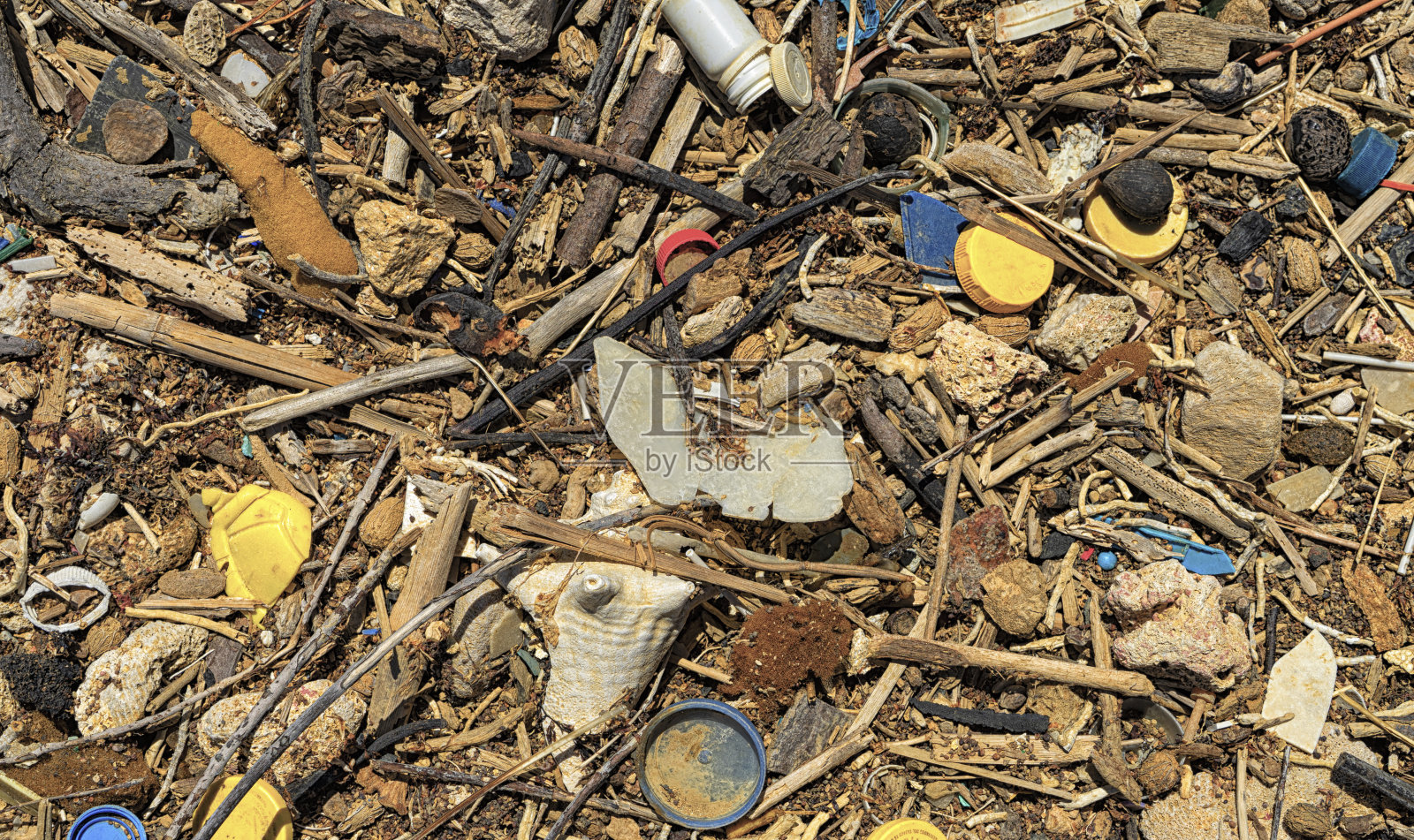 碎片和许多塑料一起冲到了岸上照片摄影图片