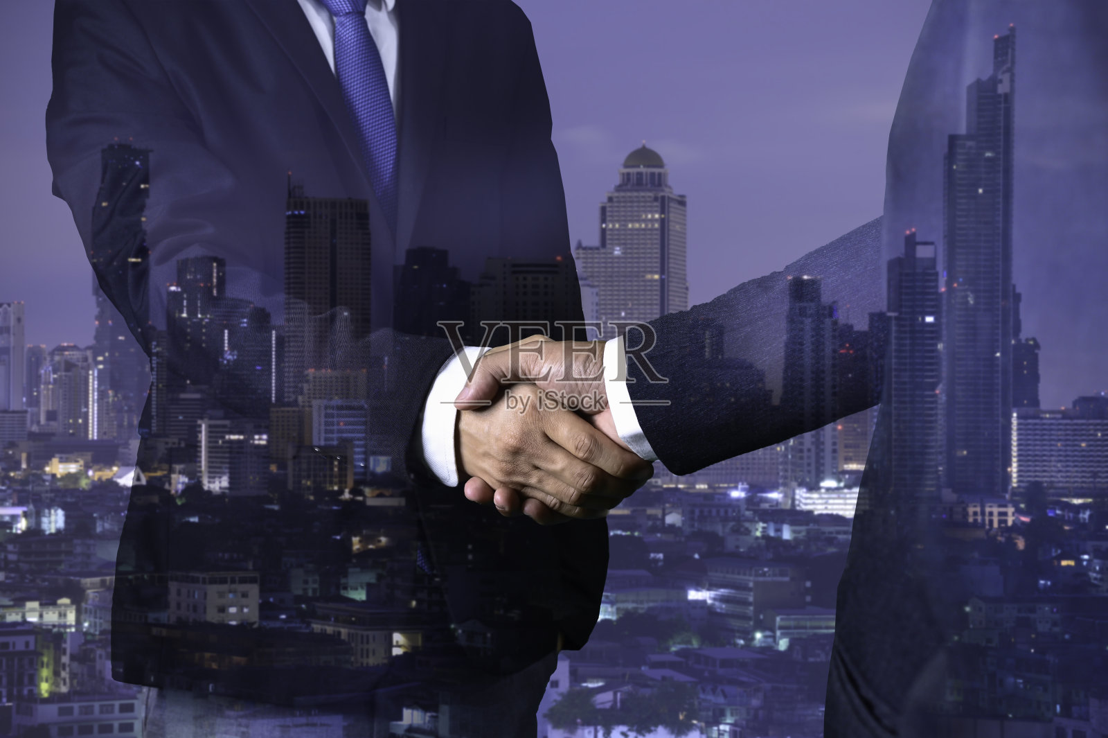 双曝光商业握手为成功的投资交易和城市夜背景，团队合作和合作理念。照片摄影图片