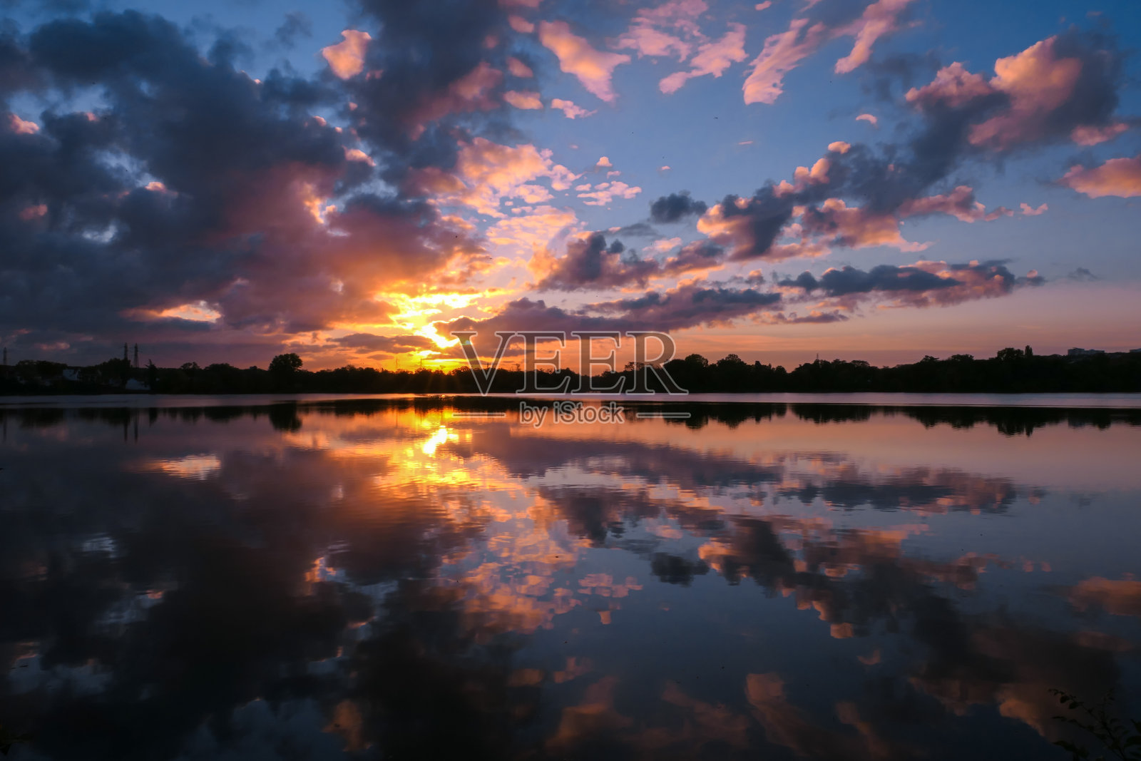 日落时湖面上对称的天空。照片摄影图片