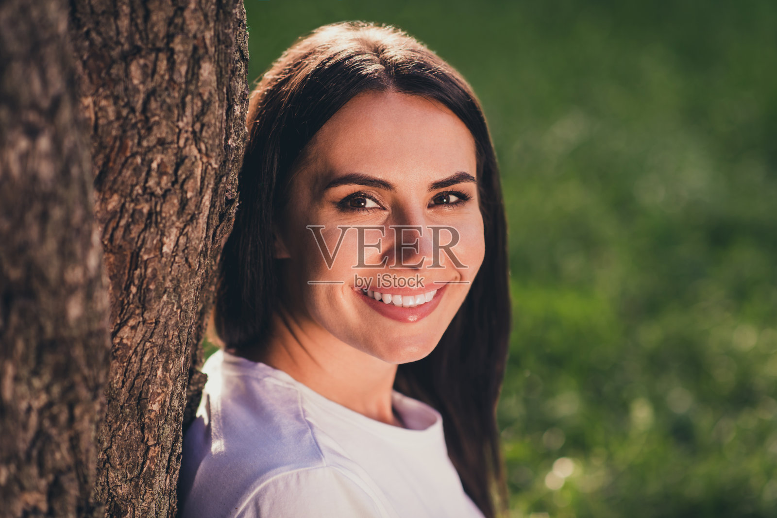 特写的侧面，她的肖像，她很漂亮，很可爱，愉快，愉快的黑发女孩花空闲时间在纯绿色的草草坪，乡村村庄度假假期照片摄影图片