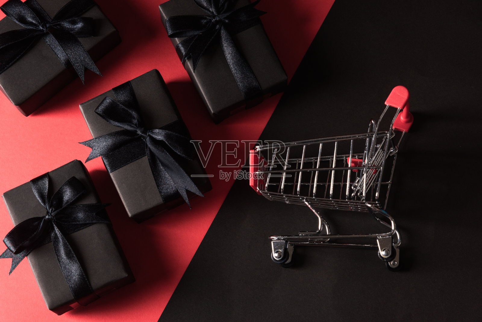 礼盒用黑色的纸和黑色的蝴蝶结丝带包裹着礼物和购物车照片摄影图片