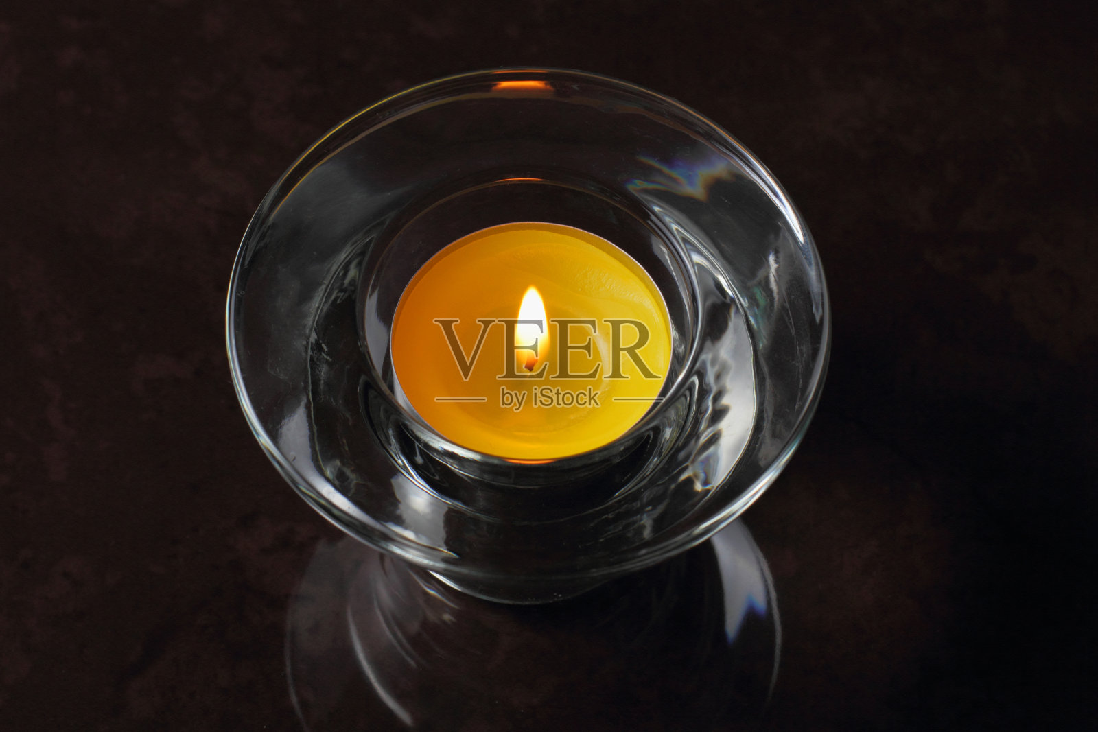 燃烧的蜡烛在玻璃烛台上的黑色背景，记忆或节日气氛的概念。照片摄影图片