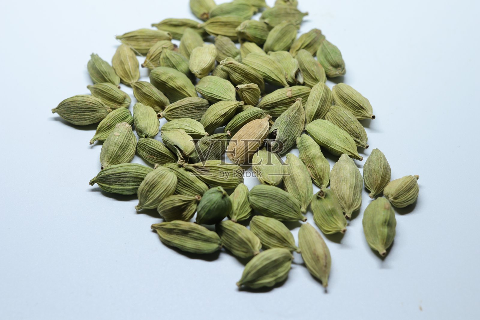 分离在白色背景上的绿色干小豆蔻种子照片摄影图片