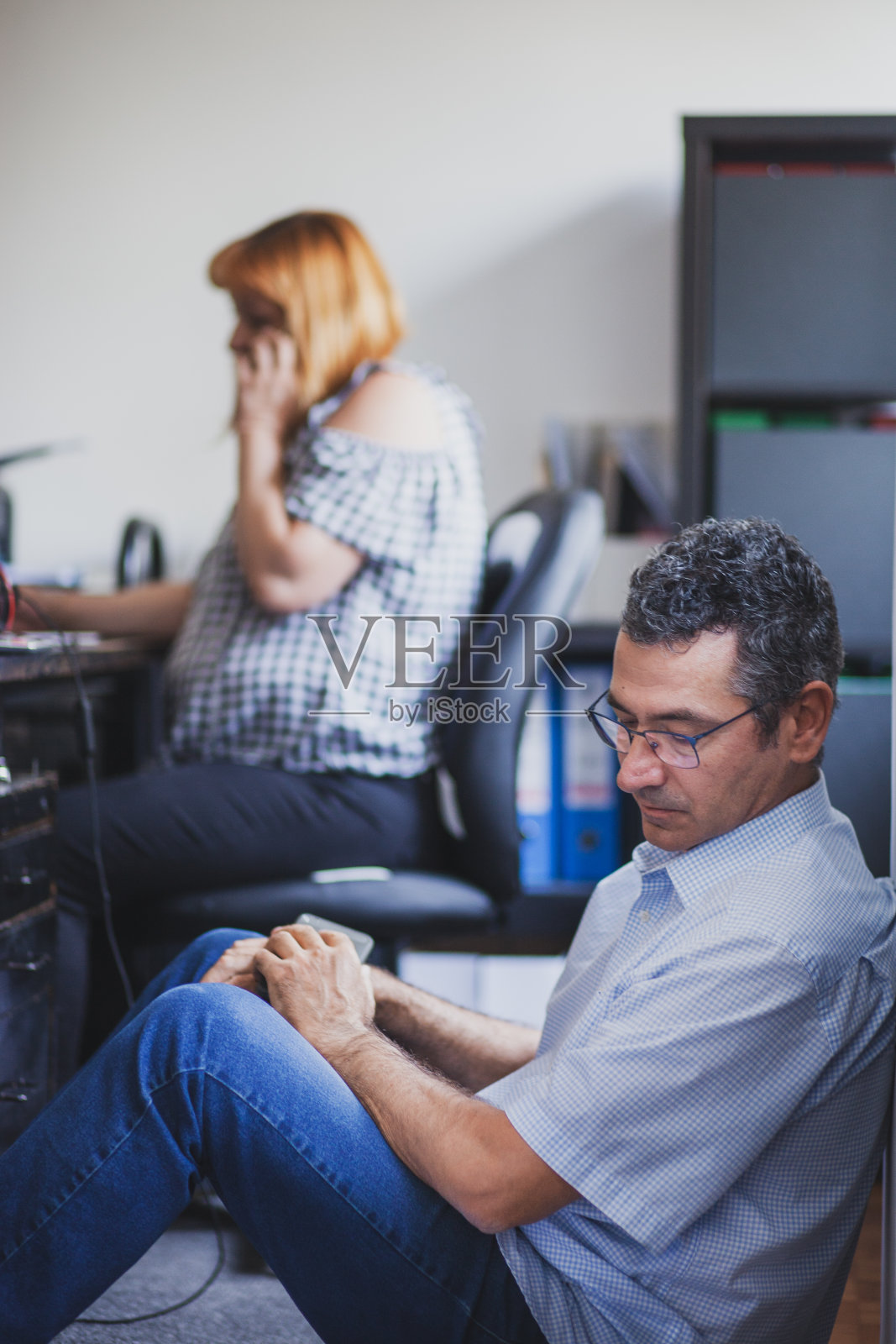 商务人员在办公室工作并通过电话进行沟通照片摄影图片