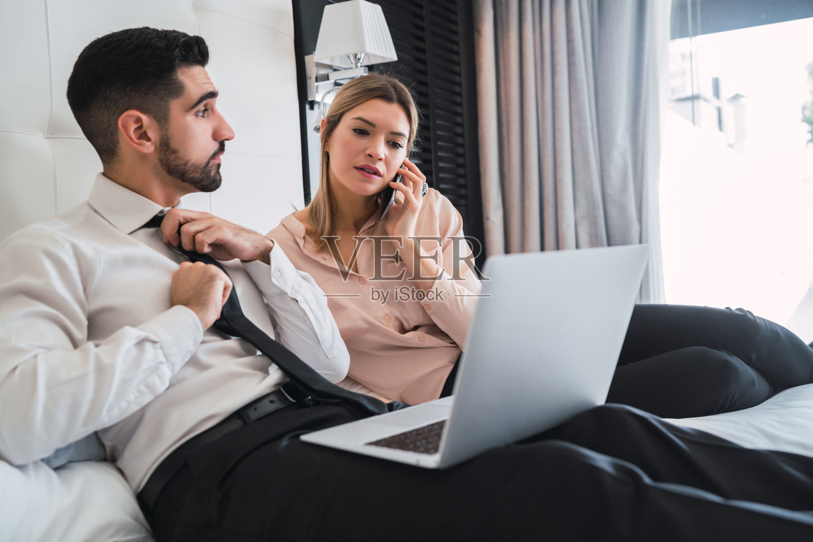 两个商人一起用笔记本电脑工作。照片摄影图片