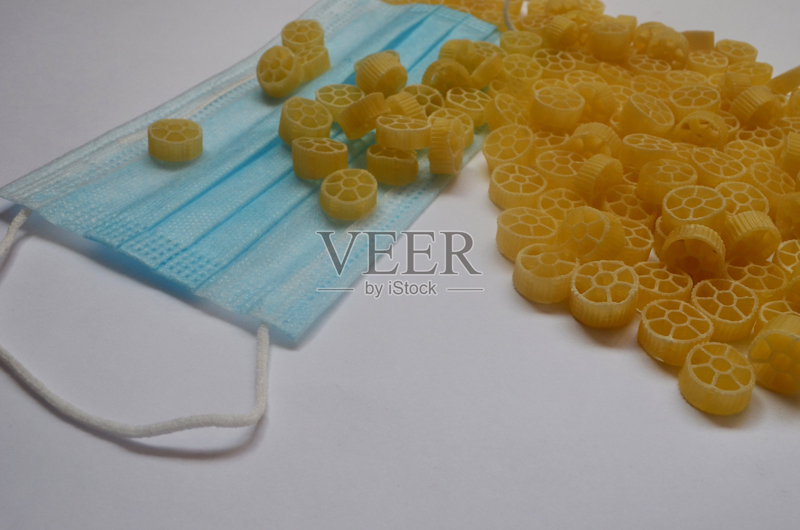 将生意大利面放在白色盘子上，并戴上保护面罩。隔离。配给照片摄影图片