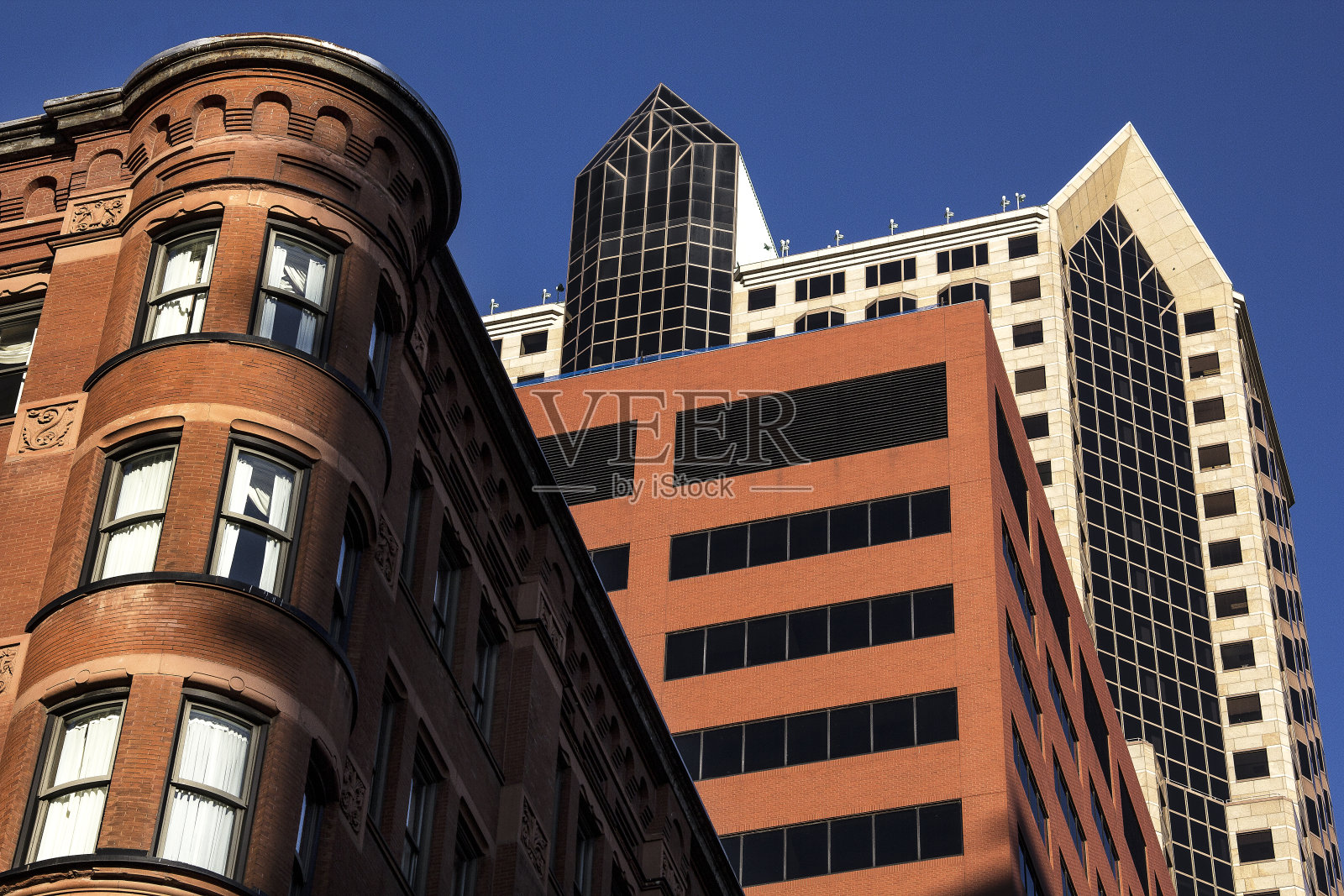 旧的历史红砖办公大楼与圆形的法国角楼在城市的现代办公大楼旁边照片摄影图片